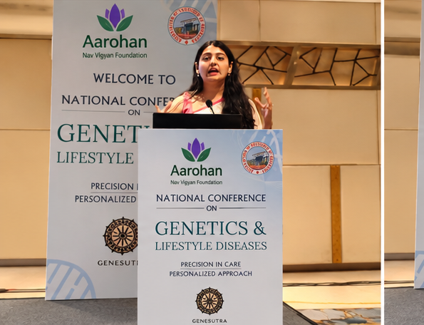 A speaker presenting from the lectern beside the conference banner