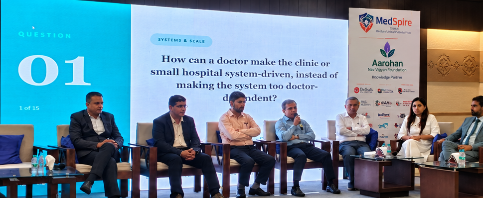 The panel seated on stage as the first question is displayed on screen