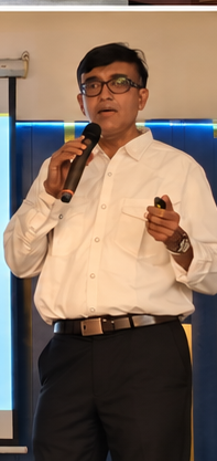 A speaker addressing delegates with a microphone