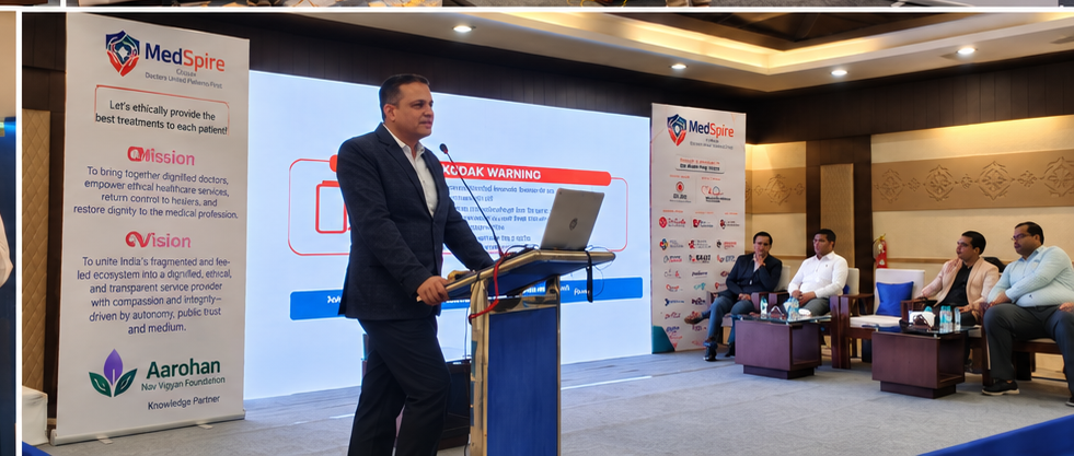 A speaker presenting from the lectern in front of the MedSpire banners